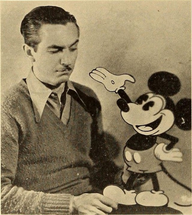 Walt Disney holding an animated Mickey Mouse