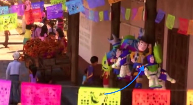Buzz, Andy, and Mike Wazowski piñatas hanging on a stand